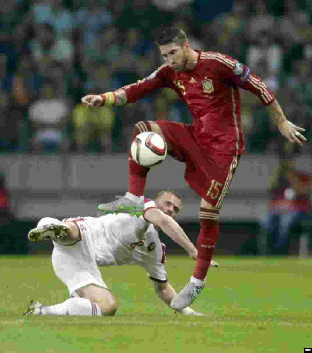 Sergio Ramos de la selección española pelea un balón con Sergei Kornilenko (L) de Belarus durante el encuentro clasificatorio para la Eurocopa 2016, que disputaron el domingo 14 de junio en el estadio Borisov Arena. Un día antes de volar a La Habana. 